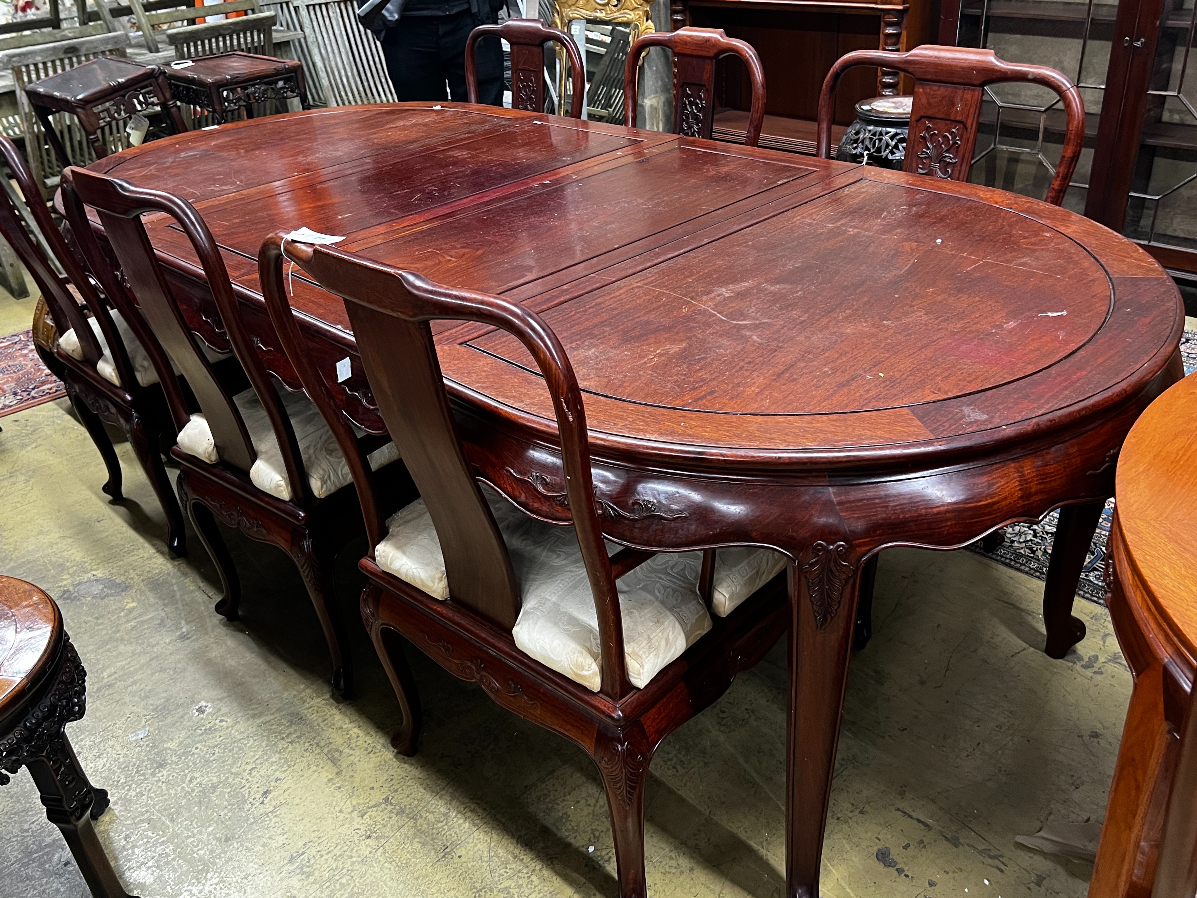 A Chinese hardwood extending dining table, length 244cm extended, two spare leaves, width 110cm, height 78cm and six chairs (2 with arms)